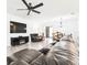 Open living area with leather seating, TV, ceiling fan, and view into the dining area at 8174 Wheat Stone Dr, Zephyrhills, FL 33540