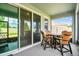 Screen enclosed patio with outdoor dining set, featuring outdoor views of manicured backyard at 8174 Wheat Stone Dr, Zephyrhills, FL 33540