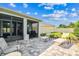 A paver patio offers lounge chairs and a grill, with a screened-in porch visible in the background at 8174 Wheat Stone Dr, Zephyrhills, FL 33540