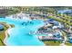 Stunning aerial view of a resort-style community featuring a large lagoon, white sand beaches, and multiple amenities at 8210 Juning Cv, Wesley Chapel, FL 33545