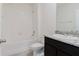 Well-lit bathroom showcasing a granite vanity, white tile, and bathtub with shower, creating a functional and clean space at 8210 Juning Cv, Wesley Chapel, FL 33545