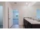 Bathroom featuring dual sinks, attractive countertops, and an open doorway at 8210 Juning Cv, Wesley Chapel, FL 33545