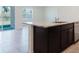 Kitchen island with dark cabinets, granite countertops, and a stainless steel dishwasher at 8210 Juning Cv, Wesley Chapel, FL 33545