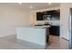 Well-lit kitchen featuring dark cabinets, stainless steel appliances, and an island with sleek countertops at 8210 Juning Cv, Wesley Chapel, FL 33545