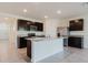 Modern kitchen with stainless steel appliances, dark cabinetry, and a large center island with granite countertops at 8210 Juning Cv, Wesley Chapel, FL 33545