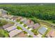 Aerial view of a well-maintained neighborhood surrounded by lush greenery and a tranquil pond at 9751 Conservation Dr, New Port Richey, FL 34655