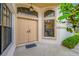 Close-up of the double front doors with an arched window, framed by manicured landscaping at 9751 Conservation Dr, New Port Richey, FL 34655