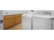 Laundry room with washer, dryer, utility sink, and wooden cabinets for storage at 9751 Conservation Dr, New Port Richey, FL 34655