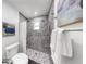 Bathroom featuring tiled shower with window, mosaic stone shower floor, and black and white floor at 9903 Saddle Rd, Tampa, FL 33626