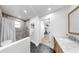 Bathroom featuring tiled shower, stone floors, vanity with wood cabinets, and a pendant light at 9903 Saddle Rd, Tampa, FL 33626