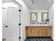 Bathroom featuring a double sink vanity, hexagon tile floors, and wood framed mirrors at 9903 Saddle Rd, Tampa, FL 33626