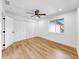 Bright bedroom with wood-look floors, ceiling fan, and closets at 9903 Saddle Rd, Tampa, FL 33626