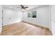 Bright, airy bedroom featuring wood floors, a ceiling fan, and a large window at 9903 Saddle Rd, Tampa, FL 33626