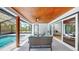 Screened lanai with ceiling fan and cozy seating area overlooking the pool and backyard at 9903 Saddle Rd, Tampa, FL 33626