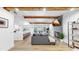 Open-concept living room with wood beams, modern decor, fireplace and seamless flow to the kitchen at 9903 Saddle Rd, Tampa, FL 33626