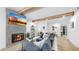 Open-concept living room with wood beams, modern decor, fireplace and seamless flow to the kitchen at 9903 Saddle Rd, Tampa, FL 33626