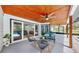 Relaxing covered patio with modern seating, wood ceiling with fan, overlooks the pool and backyard at 9903 Saddle Rd, Tampa, FL 33626