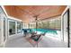 Charming patio with stylish furniture, wood ceiling with fan, and views of the pool and backyard at 9903 Saddle Rd, Tampa, FL 33626