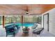 Inviting covered patio with wood ceiling, ceiling fan, stylish seating, and views of the pool at 9903 Saddle Rd, Tampa, FL 33626