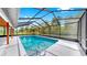 Large screened-in pool with a spacious deck and lush green surroundings, perfect for relaxation at 9903 Saddle Rd, Tampa, FL 33626