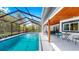 Exterior view of screened-in pool and patio area with modern outdoor furniture at 9903 Saddle Rd, Tampa, FL 33626