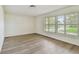 Sunny bedroom features pristine paint, luxury vinyl flooring, and large windows at 1443 54Th Ne Ave, St Petersburg, FL 33703