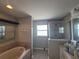 Bathroom featuring oval tub, tile surround, and glass shower at 1015 Windton Oak Dr, Ruskin, FL 33570