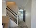 Hallway leading to the kitchen with white walls, staircase, and an open doorway at 1015 Windton Oak Dr, Ruskin, FL 33570