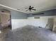 Living room with white walls, ceiling fan, wainscoting, and open space at 1015 Windton Oak Dr, Ruskin, FL 33570