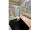 Bathroom with tiled shower, vanity and black granite floors at 1025 82Nd N Ter # 1025D, St Petersburg, FL 33702