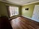 The room has wood floors, light green walls, and natural light shining in from the window at 1025 82Nd N Ter # 1025D, St Petersburg, FL 33702