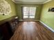 Empty room with green walls, a window, wood floors, and a dark cabinet at 1025 82Nd N Ter # 1025D, St Petersburg, FL 33702