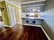 Dining area showing the wood flooring, and opening to the kitchen with a breakfast bar at 1025 82Nd N Ter # 1025D, St Petersburg, FL 33702