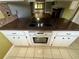 Kitchen features stone countertops, white cabinets, and modern electric stovetop oven at 1025 82Nd N Ter # 1025D, St Petersburg, FL 33702
