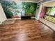 Bright living room featuring wood floors, scenic wallpaper, and access to a screened lanai at 1025 82Nd N Ter # 1025D, St Petersburg, FL 33702