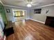 Open living space with wood floors and a sliding door to a screened balcony overlooking lush trees at 1025 82Nd N Ter # 1025D, St Petersburg, FL 33702