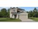 Charming two-story home showcasing a traditional design, landscaped yard, and an attached two-car garage at 11678 Brae Way, Dade City, FL 33525
