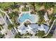 An aerial view of a community pool with ample seating surrounded by trees, and a nearby parking lot at 12004 Legacy Bright St, Riverview, FL 33578