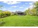 Lush backyard featuring green grass, plantings, and a screened patio on a sunny day at 12004 Legacy Bright St, Riverview, FL 33578