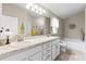 Bright bathroom featuring double sinks, a large mirror, and a separate soaking tub at 12004 Legacy Bright St, Riverview, FL 33578