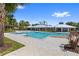 Resort style community pool and pavilion with nearby lounge seating, tropical plants, and playground at 12004 Legacy Bright St, Riverview, FL 33578