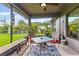 Relaxing screened porch with patio furniture and a view of the manicured backyard at 12004 Legacy Bright St, Riverview, FL 33578