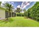 Expansive backyard featuring verdant lawn and lush greenery, offering privacy and space for recreation at 1208 Carriage Park Dr, Valrico, FL 33594