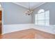 Bright dining room featuring hardwood floors, wainscoting, chandelier, and natural light from large windows at 1208 Carriage Park Dr, Valrico, FL 33594