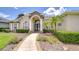 Charming single-story home with meticulous landscaping, a stone-accented entry, and lush green hedges at 1208 Carriage Park Dr, Valrico, FL 33594