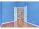 Office with blue walls, wood floors, double doors and views of the open living spaces at 1208 Carriage Park Dr, Valrico, FL 33594