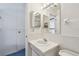 Bright bathroom with a white vanity, framed mirror, and ceramic tiled walls at 1270 Inverness, Dunedin, FL 34698