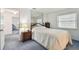 Well-lit bedroom features a comfortable bed, a mirrored accent wall and matching wooden bedside table at 1270 Inverness, Dunedin, FL 34698
