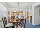 Charming dining room with a wooden table, elegant chandelier, and a view to the kitchen at 1270 Inverness, Dunedin, FL 34698