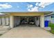 Open garage featuring a golf cart and ample storage space, plus driveway at 1270 Inverness, Dunedin, FL 34698
